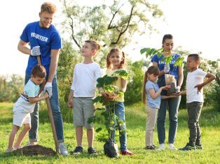 Diverse children volunteer planting trees