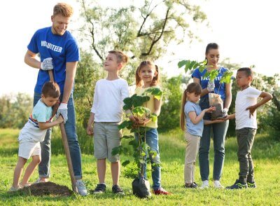 Diverse children volunteer planting trees